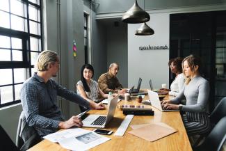 adults sitting at a conference table brainstorming